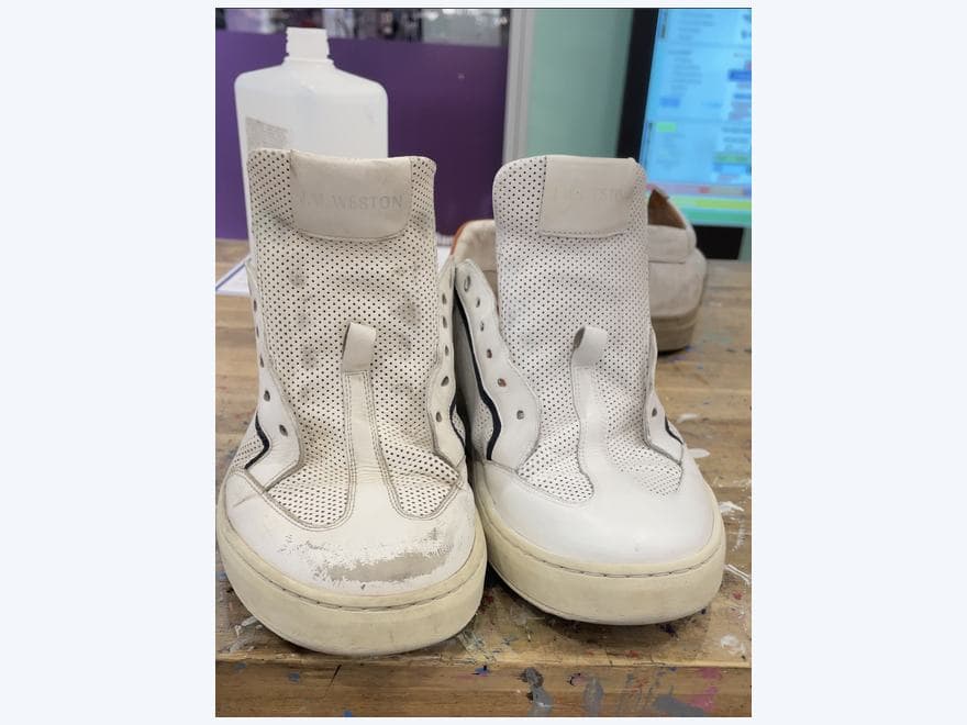 Paire de sneakers blanches examinée dans l’atelier